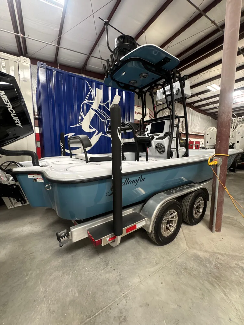 Slide: The Image of 2025 Yellowfin 24 CE boat on trailer in indoor storage facility. - 2