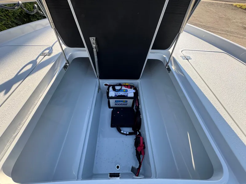 Slide: The Image of Open storage compartment of 2025 Yellowfin 24 CE boat with marine battery. - 26
