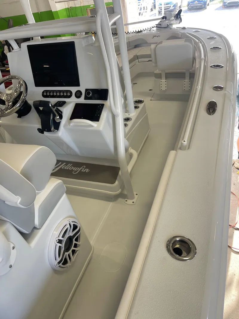 Slide: The Image of 2026 Yellowfin 26 Hybrid boat at a dealership, featuring spacious seating and modern design. - 11