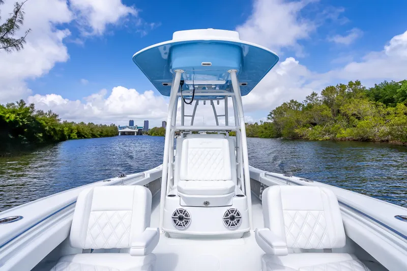 Slide: The Image of 2026 Yellowfin 26 Hybrid boat cruising on a scenic river under a blue sky. - 21