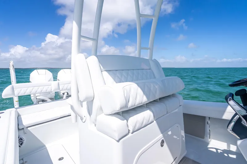 Slide: The Image of 2026 Yellowfin 26 Hybrid boat interior with white seating, ocean backdrop, and clear blue sky. - 23