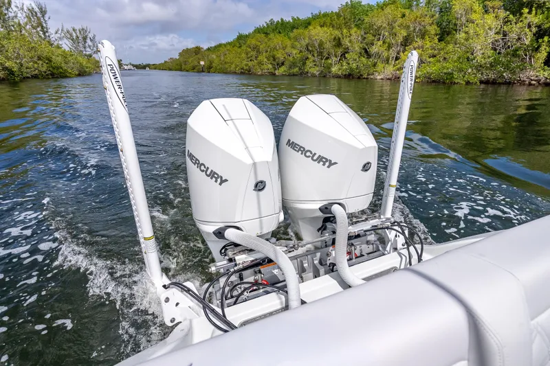 Slide: The Image of 2026 Yellowfin 26 Hybrid boat with dual Mercury outboard engines navigating a scenic waterway. - 28