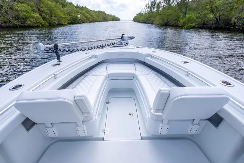 Slide: The Image of 2026 Yellowfin 26 Hybrid boat interior with white seating, cruising on a scenic waterway. - 29
