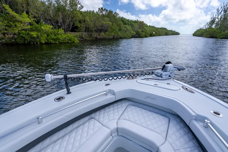 Slide: The Image of 2026 Yellowfin 26 Hybrid boat navigating a scenic, tree-lined waterway under a partly cloudy sky. - 31