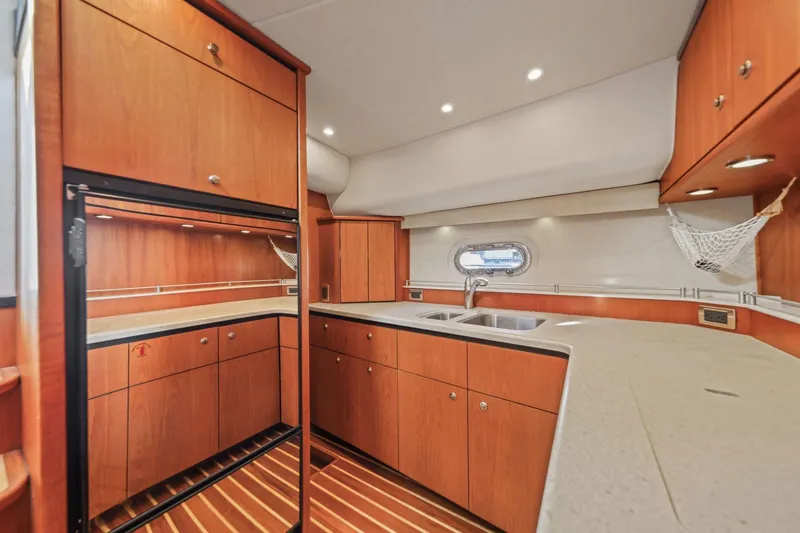 Slide: The Image of 2008 Tiara Yachts 4300 Sovran kitchen with wood cabinetry and modern appliances. - 29
