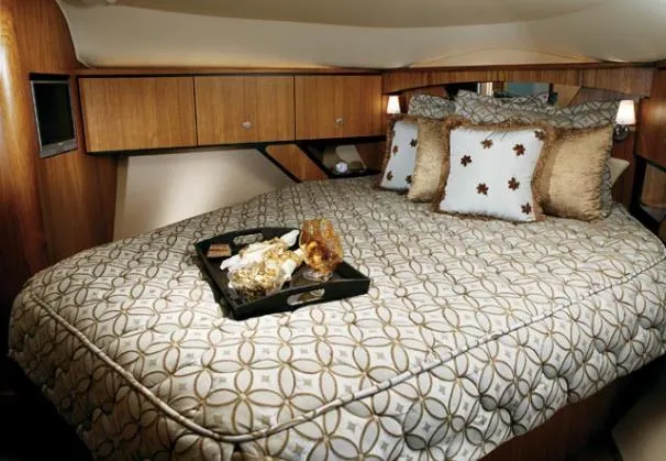 Slide: The Image of 2008 Tiara Yachts 4300 Sovran cruising on blue ocean with city skyline backdrop. - 6