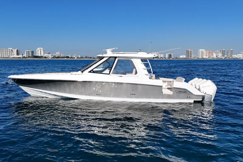 The Image of 2022 Boston Whaler 380 Realm boat on calm ocean with city skyline background. - 0