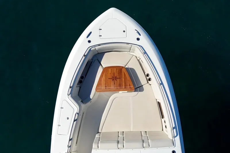 Slide: The Image of Top view of 2022 Boston Whaler 380 Realm boat's bow seating area with wooden table. - 11