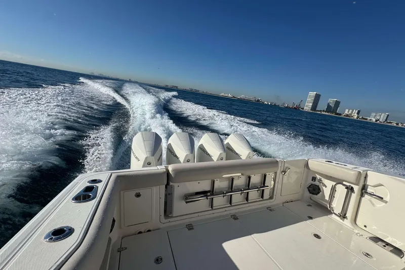 Slide: The Image of 2022 Boston Whaler 380 Realm cruising on open water with city skyline in background. - 14