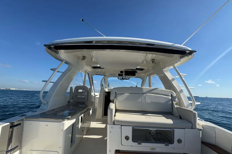 Slide: The Image of 2022 Boston Whaler 380 Realm boat interior with seating, ocean view, and clear sky. - 18