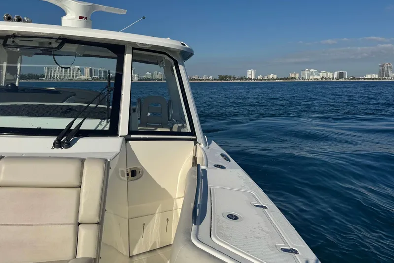 Slide: The Image of Boston Whaler 380 Realm 2022 cruising on blue ocean near city skyline. - 30