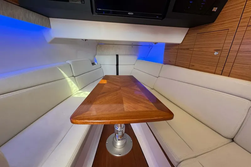 Slide: The Image of Interior of 2022 Boston Whaler 380 Realm with elegant seating and wooden table. - 36