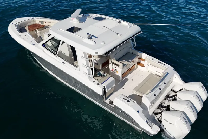 Slide: The Image of 2022 Boston Whaler 380 Realm boat on water, featuring spacious deck and triple Mercury engines. - 4