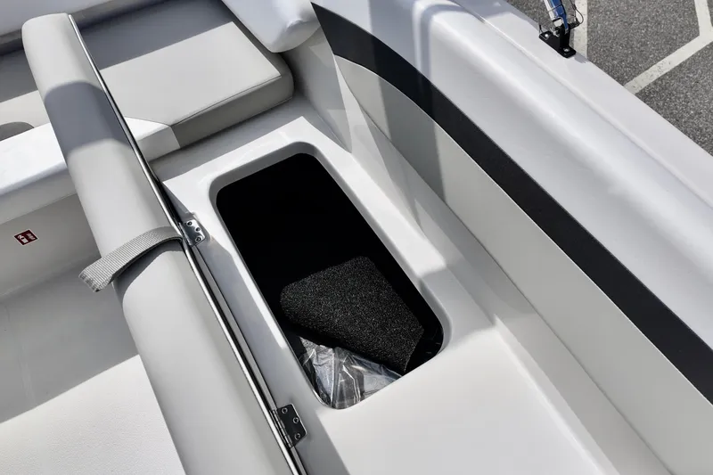 Slide: The Image of 2026 Starcraft SVX 171 OB boat storage compartment with open lid, showcasing interior space. - 10