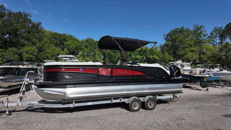 Slide: The Image of 2022 Barletta Corsa 23U pontoon boat on trailer, parked outdoors under clear blue sky. - 3