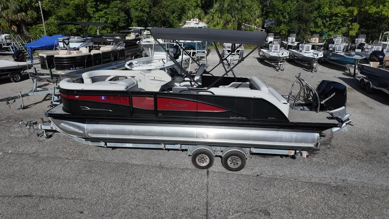 Slide: The Image of 2022 Barletta Corsa 23U pontoon boat on trailer, parked in a marina lot. - 4