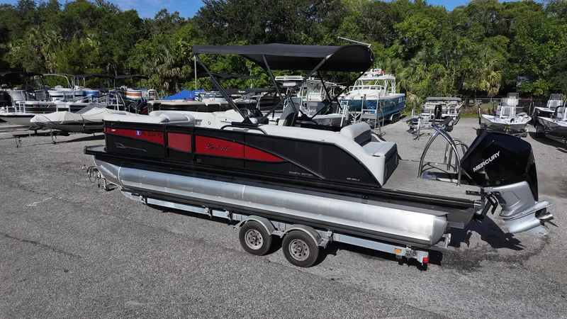 Slide: The Image of 2022 Barletta Corsa 23U pontoon boat on trailer, parked in a marina. - 5