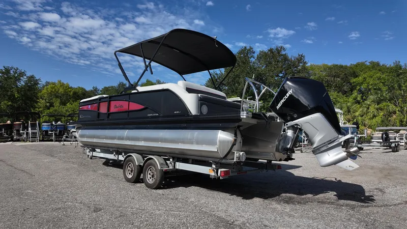Slide: The Image of 2022 Barletta Corsa 23U pontoon boat on trailer, under clear blue sky. - 6