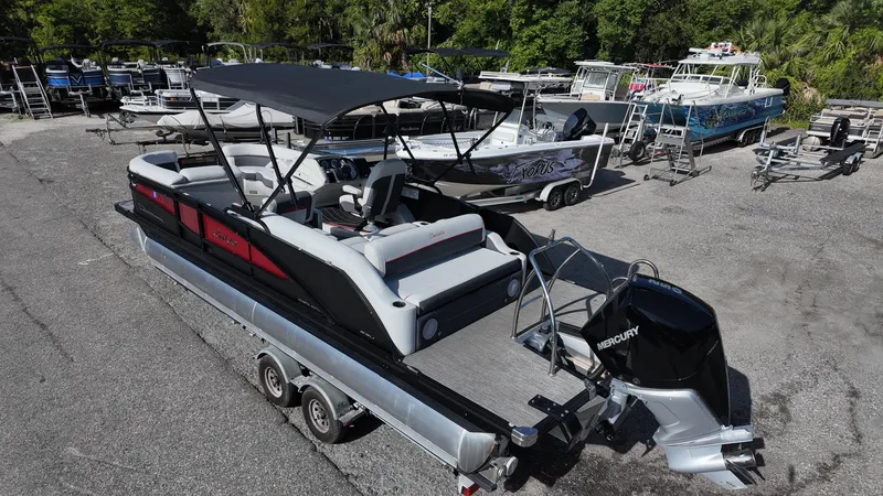 Slide: The Image of 2022 Barletta Corsa 23U pontoon boat on trailer, featuring a Mercury outboard motor. - 7