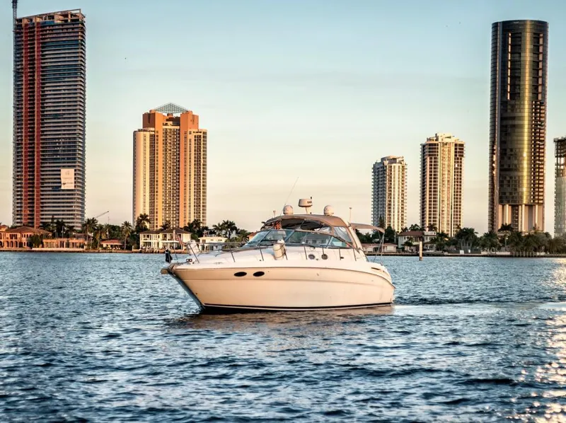 Slide: The Image of Sea Ray 380 Sundancer 2002 yacht cruising near city skyline at sunset. - 1