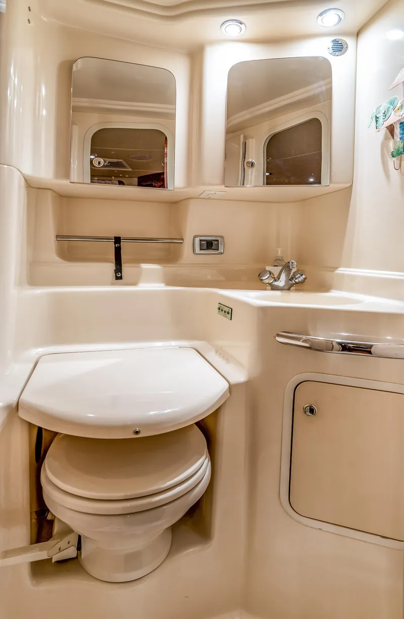 Slide: The Image of 2002 Sea Ray 380 Sundancer bathroom with sink, toilet, and mirrored cabinets. - 12