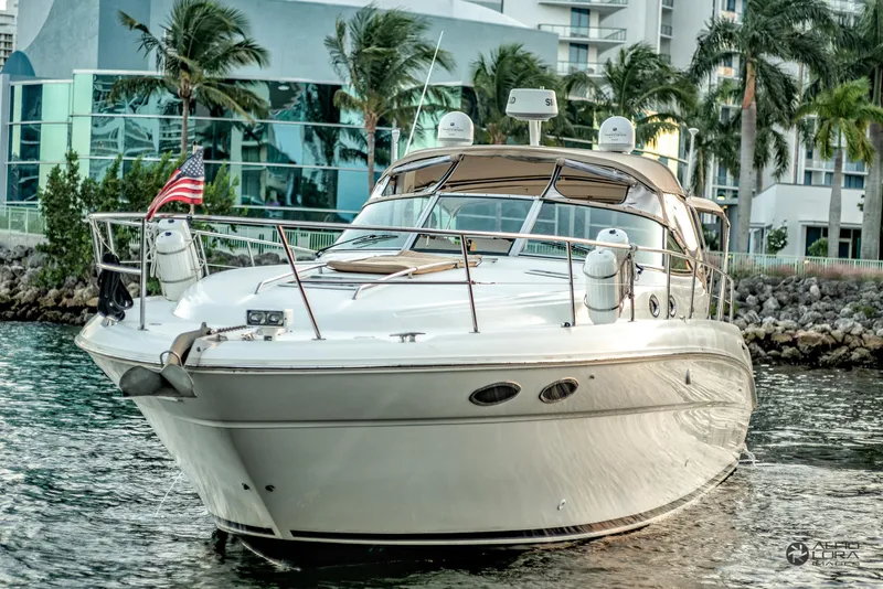 Slide: The Image of 2002 Sea Ray 380 Sundancer yacht docked near modern buildings and palm trees. - 2