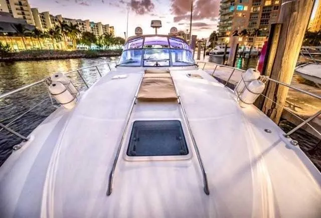 Slide: The Image of 2002 Sea Ray 380 Sundancer yacht docked at sunset with cityscape background. - 5