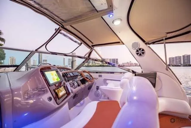 Slide: The Image of Interior view of 2002 Sea Ray 380 Sundancer yacht with modern dashboard and city skyline. - 8