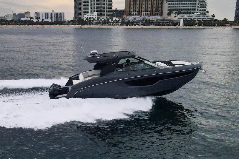 The Image of 2022 Cruisers Yachts 38 GLS speeding on water with city skyline backdrop. - 0