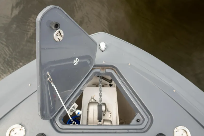 Slide: The Image of Anchor compartment of 2022 Cruisers Yachts 38 GLS, featuring open hatch and chain mechanism. - 18