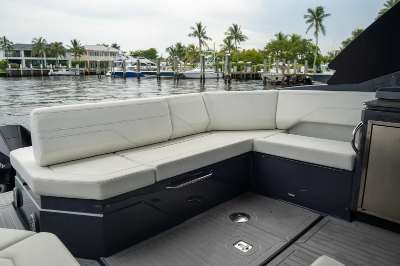 Slide: The Image of 2022 Cruisers Yachts 38 GLS with luxurious seating, docked by waterfront homes and palm trees. - 19