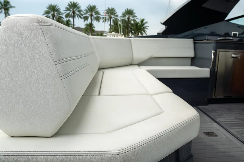 Slide: The Image of 2022 Cruisers Yachts 38 GLS interior with white seating and palm trees in the background. - 20