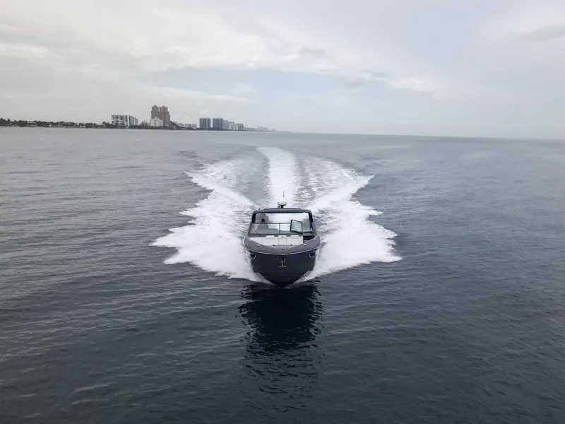 Slide: The Image of 2022 Cruisers Yachts 38 GLS speeding on open water, cityscape in background. - 3