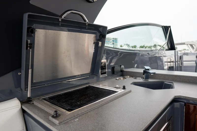 Slide: The Image of Outdoor kitchen area on 2022 Cruisers Yachts 38 GLS, featuring a grill and sink. - 31