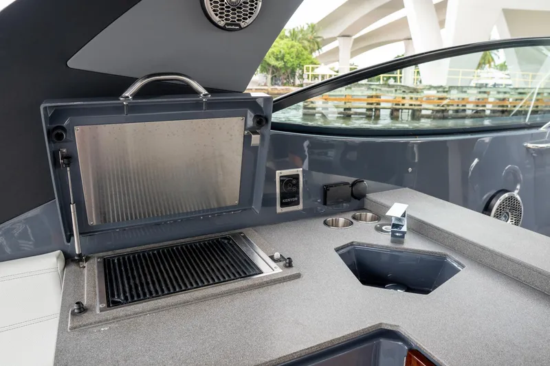 Slide: The Image of Outdoor kitchen area on 2022 Cruisers Yachts 38 GLS, featuring a grill and sink. - 32