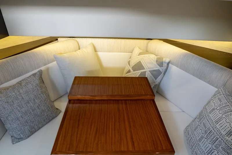 Slide: The Image of 2022 Cruisers Yachts 38 GLS interior with cushioned seating and wooden table. - 49