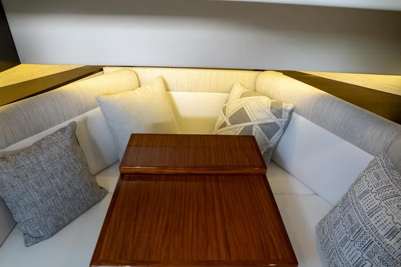 Slide: The Image of 2022 Cruisers Yachts 38 GLS interior with cushioned seating and wooden table. - 48
