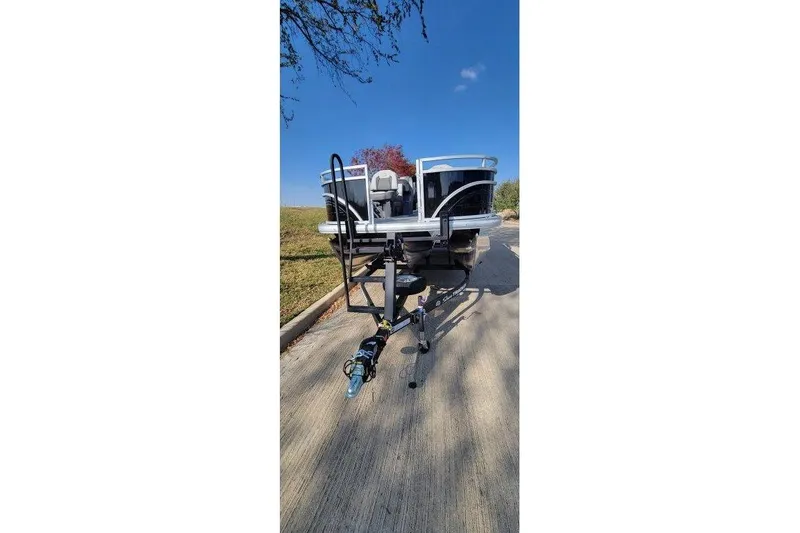 Slide: The Image of 2026 Sun Tracker Fishin' Barge 22 XP3 on trailer, parked on a sunny day. - 2