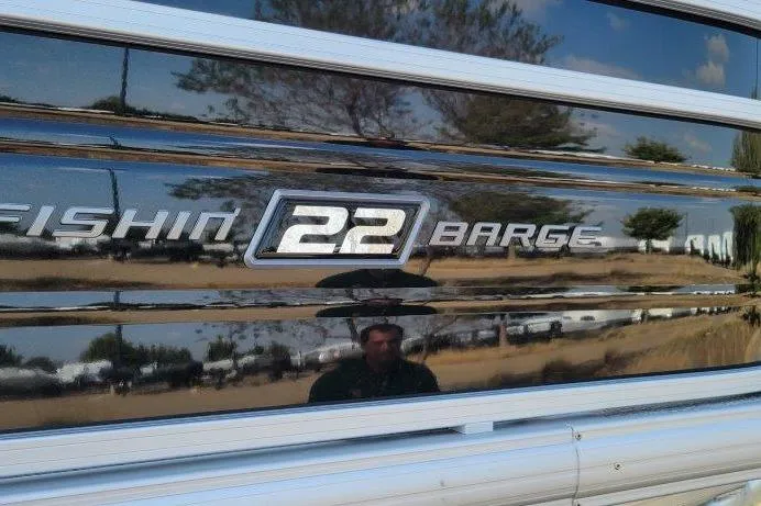 Slide: The Image of 2026 Sun Tracker Fishin' Barge 22 XP3 logo on reflective surface. - 4
