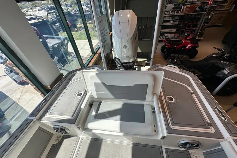 Slide: The Image of 2026 Mako 24 APEX boat interior with seating and motor, displayed indoors. - 9