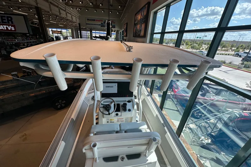 Slide: The Image of Interior view of 2026 Mako 24 APEX boat with steering console and rod holders. - 7