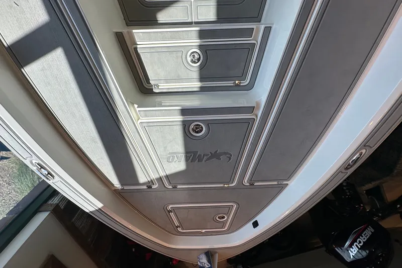 Slide: The Image of 2026 Mako 24 APEX boat deck with storage compartments and logo. - 11