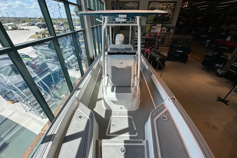 Slide: The Image of 2026 Mako 24 APEX boat interior, showcasing sleek design and spacious layout in showroom. - 12