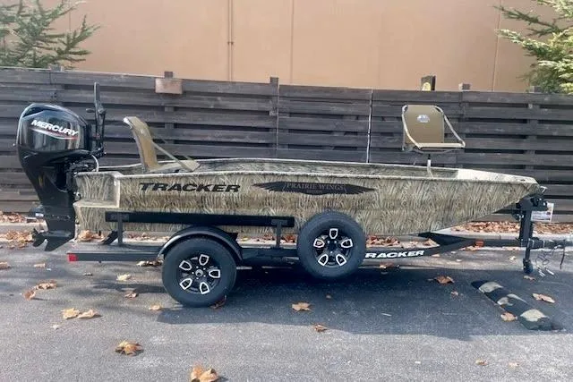 Slide: The Image of 2026 Tracker Grizzly 1650 T Prairie Wings Edition boat on trailer, camo design, parked outdoors. - 2