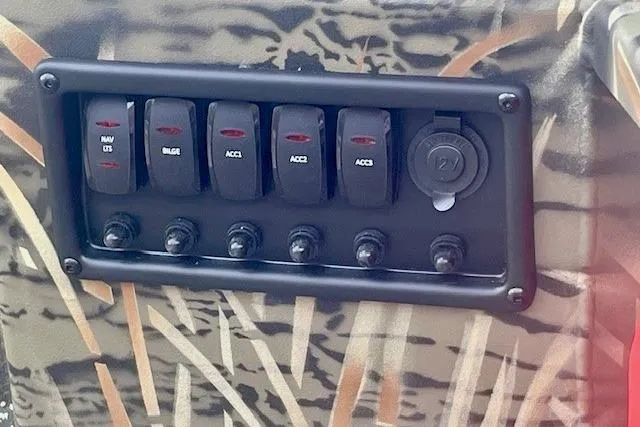 Slide: The Image of Control panel of 2026 Tracker Grizzly 1650 T Prairie Wings Edition with camo design. - 3