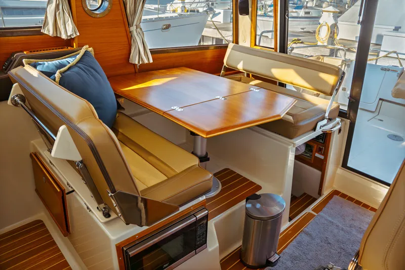 Slide: The Image of 2022 Ranger Tugs R-29 S interior with dining area and wooden table. - 18