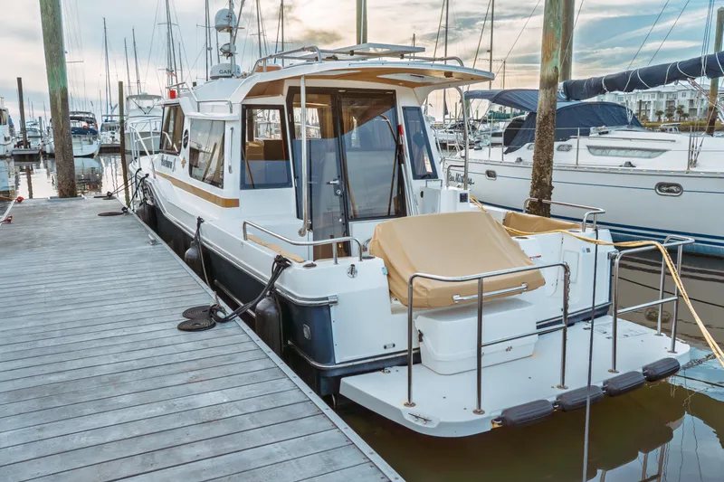 Slide: The Image of 2022 Ranger Tugs R-29 S docked at marina, showcasing sleek design and modern features. - 2