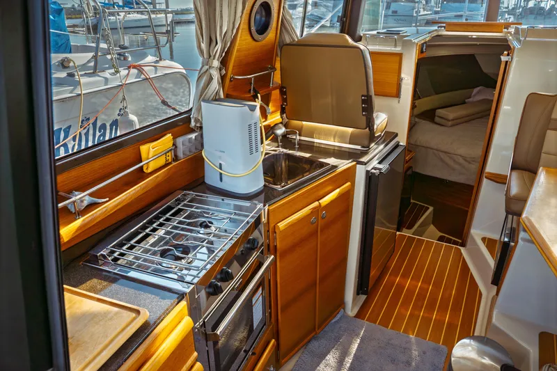 Slide: The Image of 2022 Ranger Tugs R-29 S interior with kitchen, stove, sink, and cozy cabin. - 24