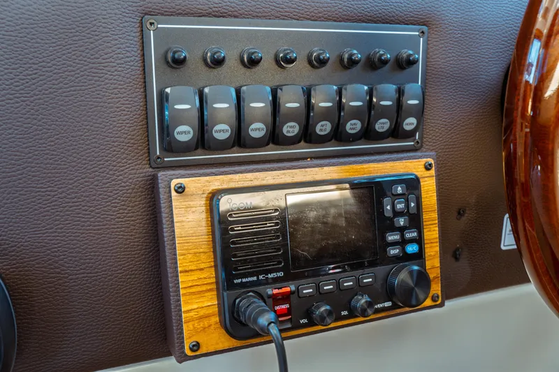Slide: The Image of Control panel of 2022 Ranger Tugs R-29 S with switches and marine radio. - 35