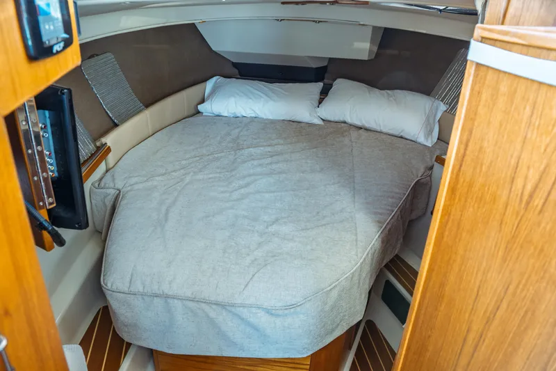 Slide: The Image of 2022 Ranger Tugs R-29 S cabin interior with cozy bed and wooden accents. - 38